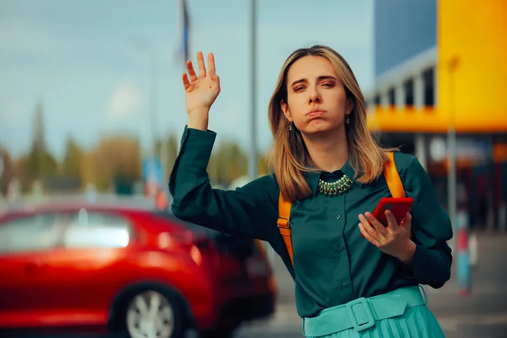 Woman Holding a Mobile Using Taxi App Waving a Car