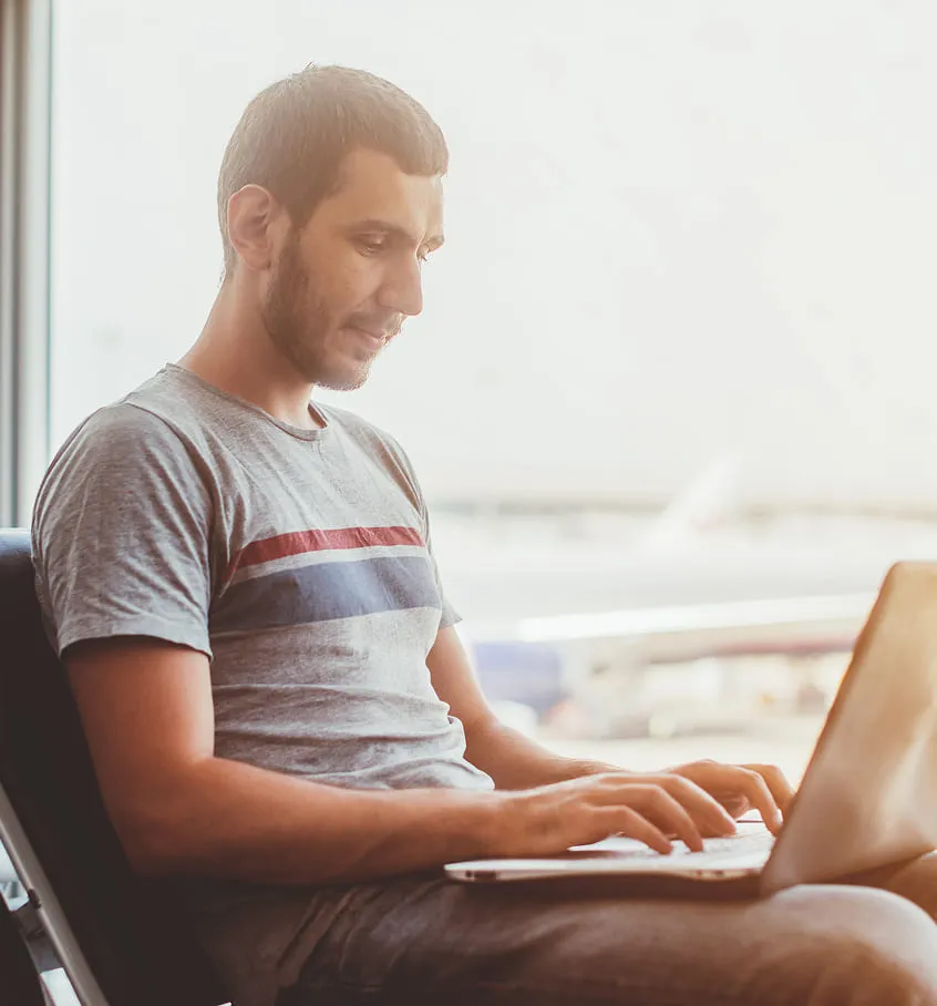 Man working on his computer at airport